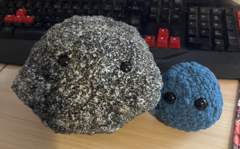 two crochet balls with big black eyes