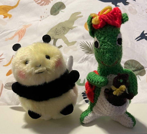 two plushies, a fat bee and a crochet kangaroo creature